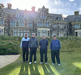 Dan Ashley standing with client group with Doonbeg Clubhouse in background